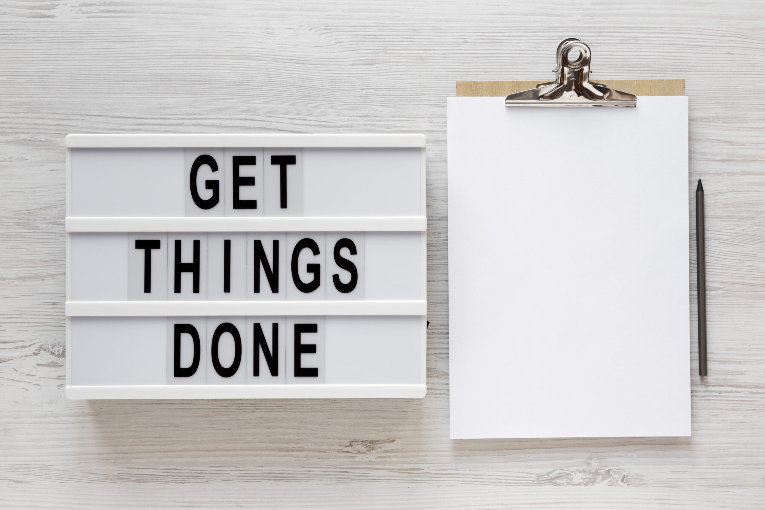 'Get things done' words on a lightbox, clipboard with blank shee